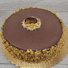 Load image into Gallery viewer, Chocolate cake with a decorative top on a wooden surface