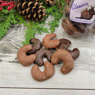 chocolate covered cookies shaped like little moons lying on a piece of wood