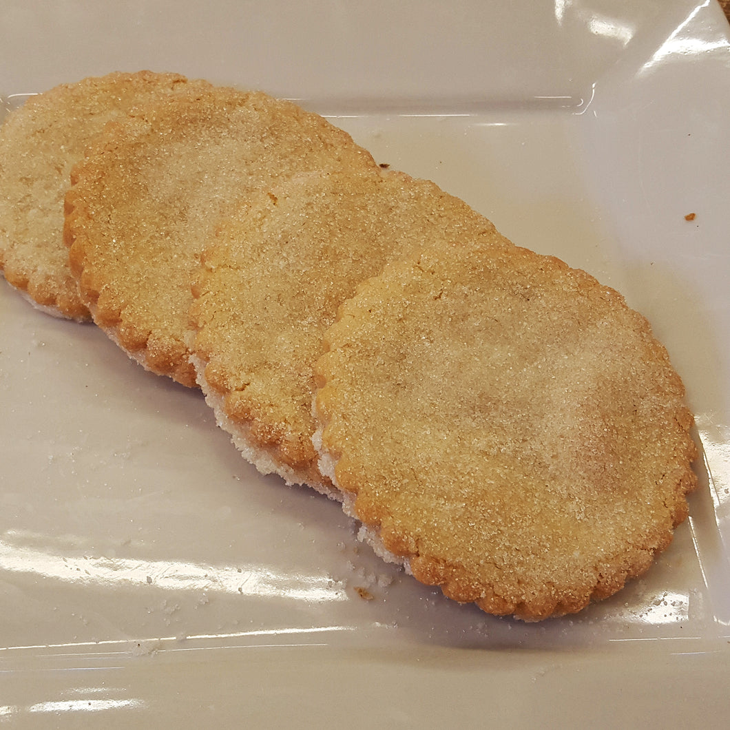 Four large sugar cookies on a white plate