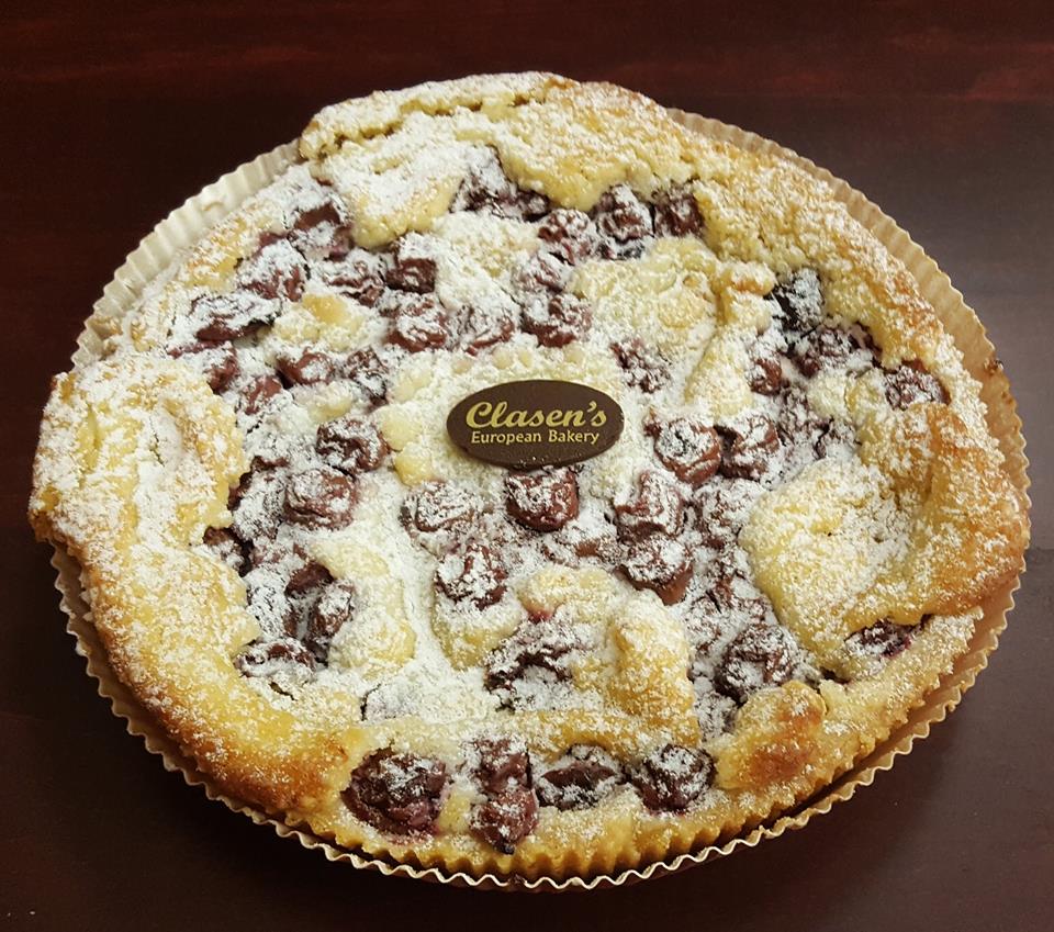 Cherry frangipane tart topped with cherries, powdered sugar and the Clasen chocolate disk