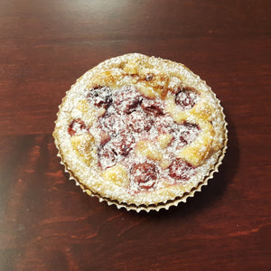 Cherry frangipane tart topped with cherries, and powdered sugar 